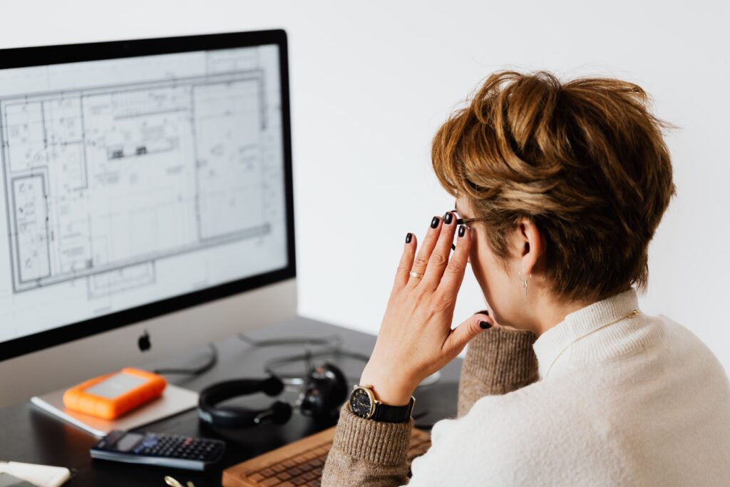 CAD specialist analyzing architectural floor plans and technical drawings on a computer screen