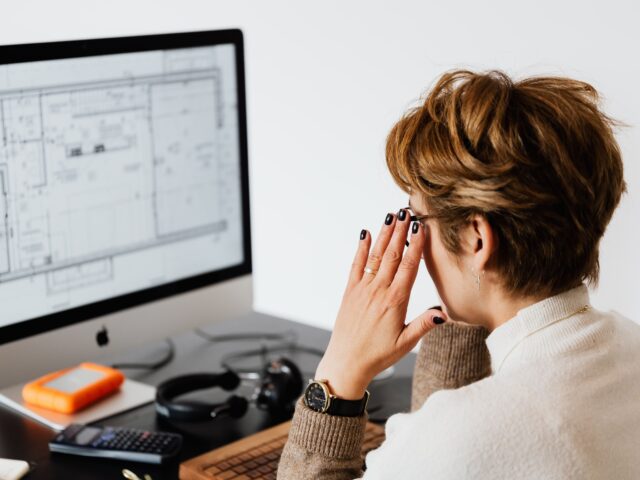 CAD specialist analyzing architectural floor plans and technical drawings on a computer screen