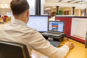 CAD drafter working on engineering drawings and BIM models in a construction office environment
