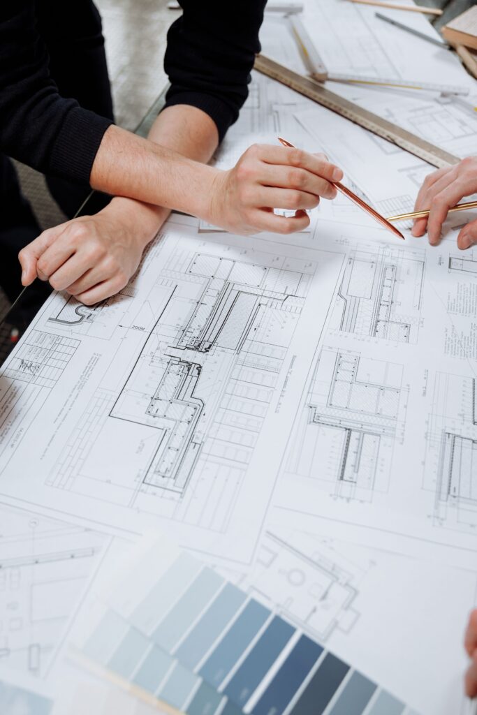 CAD professionals discussing technical drawings and construction plans during a drafting and design review.