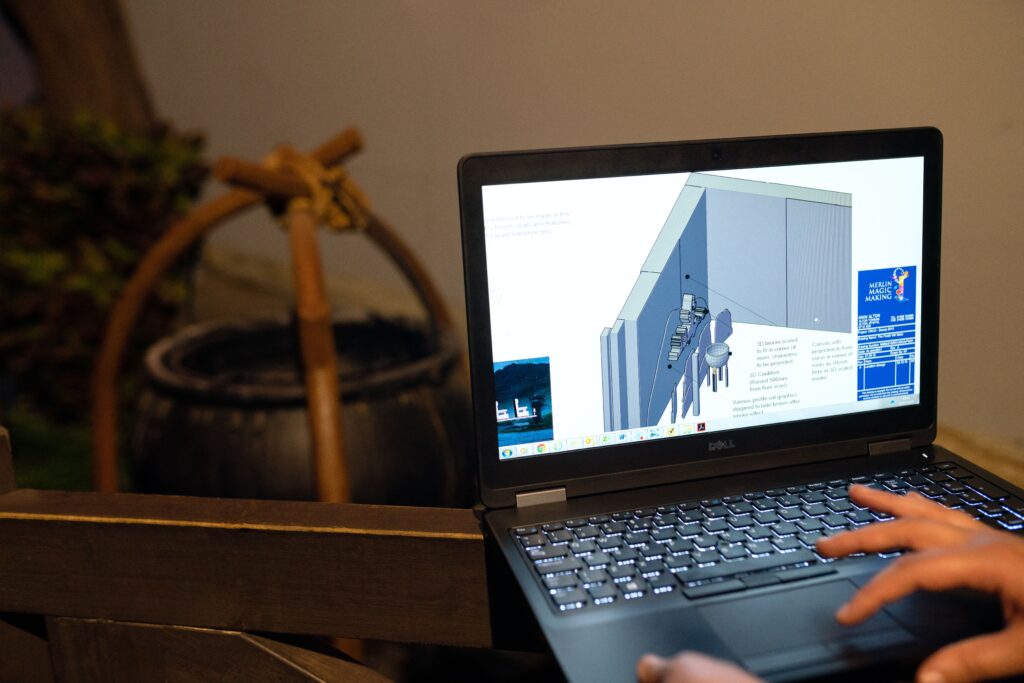 CAD production support professional reviewing 3D construction drawings on a laptop