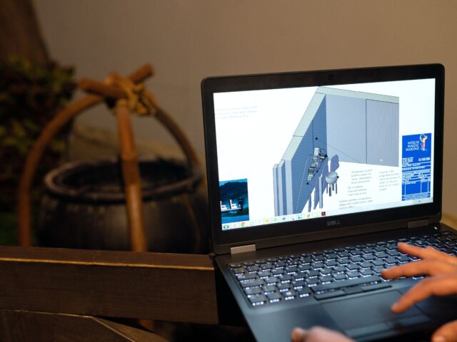 CAD production support professional reviewing 3D construction drawings on a laptop