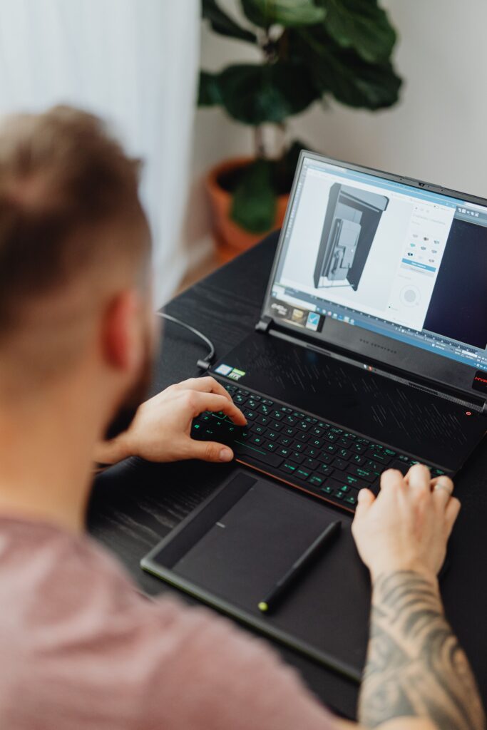 CAD drafter creating and modifying a 3D CAD model on a computer workstation.