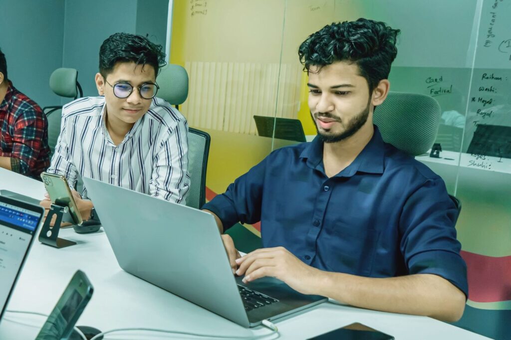Dedicated offshore professionals working on laptops in a fully managed office that supports US construction firms